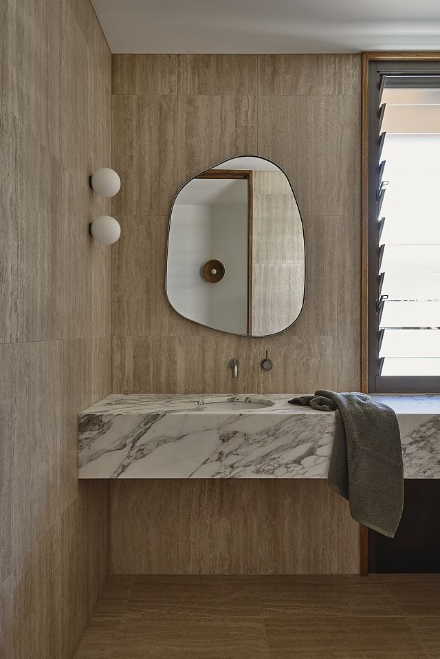 Travertine Lait floor and wall and Calcatta Vagli benchtop at Avocado House by HGA Studio. Photos by Derek Swalwell 