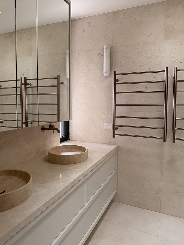 Crema Lyra ​floor and walls with Remelio​ vanity top. Interior Design ​by Chanel Sohie​r. Architect​u​re by Peter Rush​. Build​ by Layden Projects