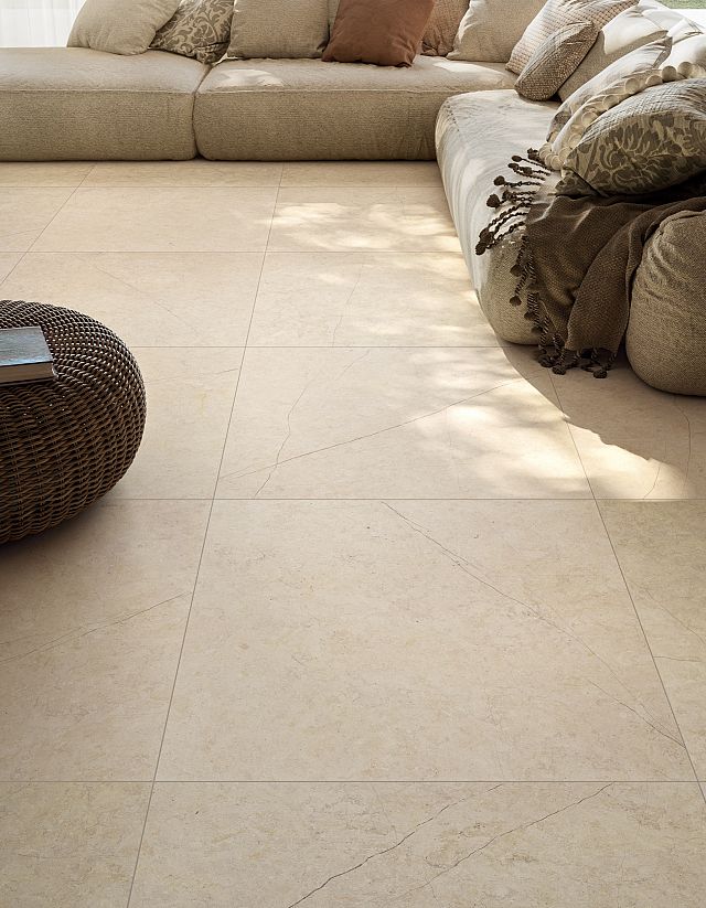 Artegres Isola Comiso Italian porcelain tile on living room floor, warm cream tones with subtle veining