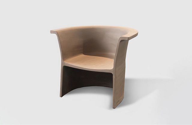 New Volumes Cove Marrone terracotta armchair designed by Thomas Coward, in warm sandy tones with sculptural curved form